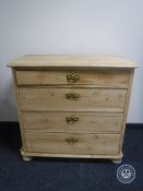 An antique pine four drawer chest on bun feet