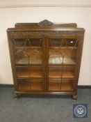 An early 20th century carved oak display cabinet,