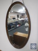 An Edwardian mahogany oval framed bevelled mirror