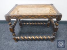 An early 20th century carved oak barley twist bergere dressing table stool