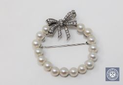 A 14ct white gold pearl and diamond set brooch