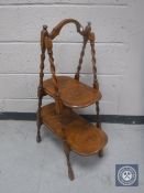 An Edwardian oak barley twist folding cake stand