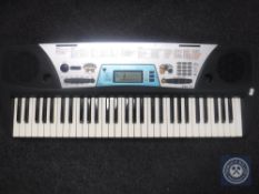 A Yamaha PSR 170 electric keyboard with lead and books