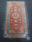 An antique Chinese hearth rug on salmon ground,