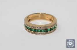 An 18ct gold emerald and diamond half-eternity ring,