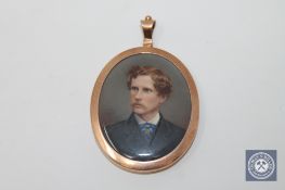 A Victorian miniature in gold frame depicting a gentleman, the reverse with lock of hair.