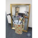 A gilt framed mirror together with a stick pot with rose decoration and four folding walking sticks
