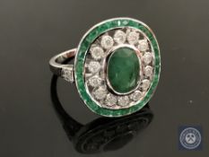 An 18ct white gold emerald and diamond ring featuring an oval cut emerald 2.