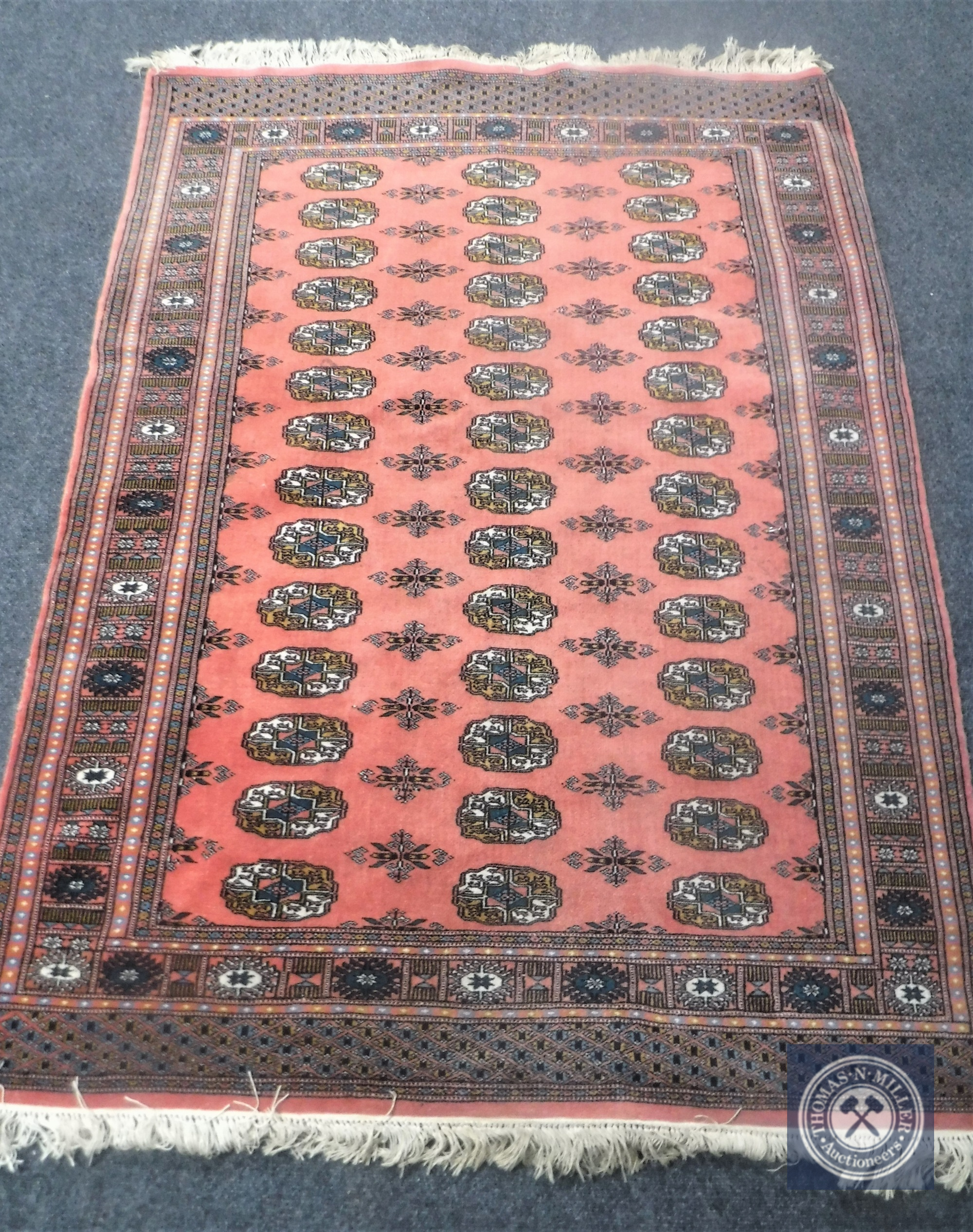 A Bokhara design rug on salmon ground,