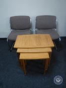 A nest of three teak effect tables and a pair of upholstered reception chairs