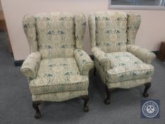 A pair of early 20th century wingback armchairs on claw and ball feet