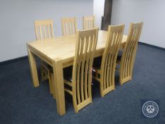 A contemporary pine kitchen table and a set of six leather seated high backed dining chairs