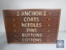 A mid 20th century teak six drawer counter topped chest containing buttons and sewing items