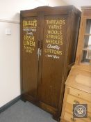 An oak double door gent's wardrobe with haberdashery advertising