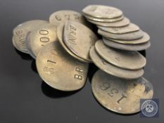 Twenty vintage brass railway pay check tokens.