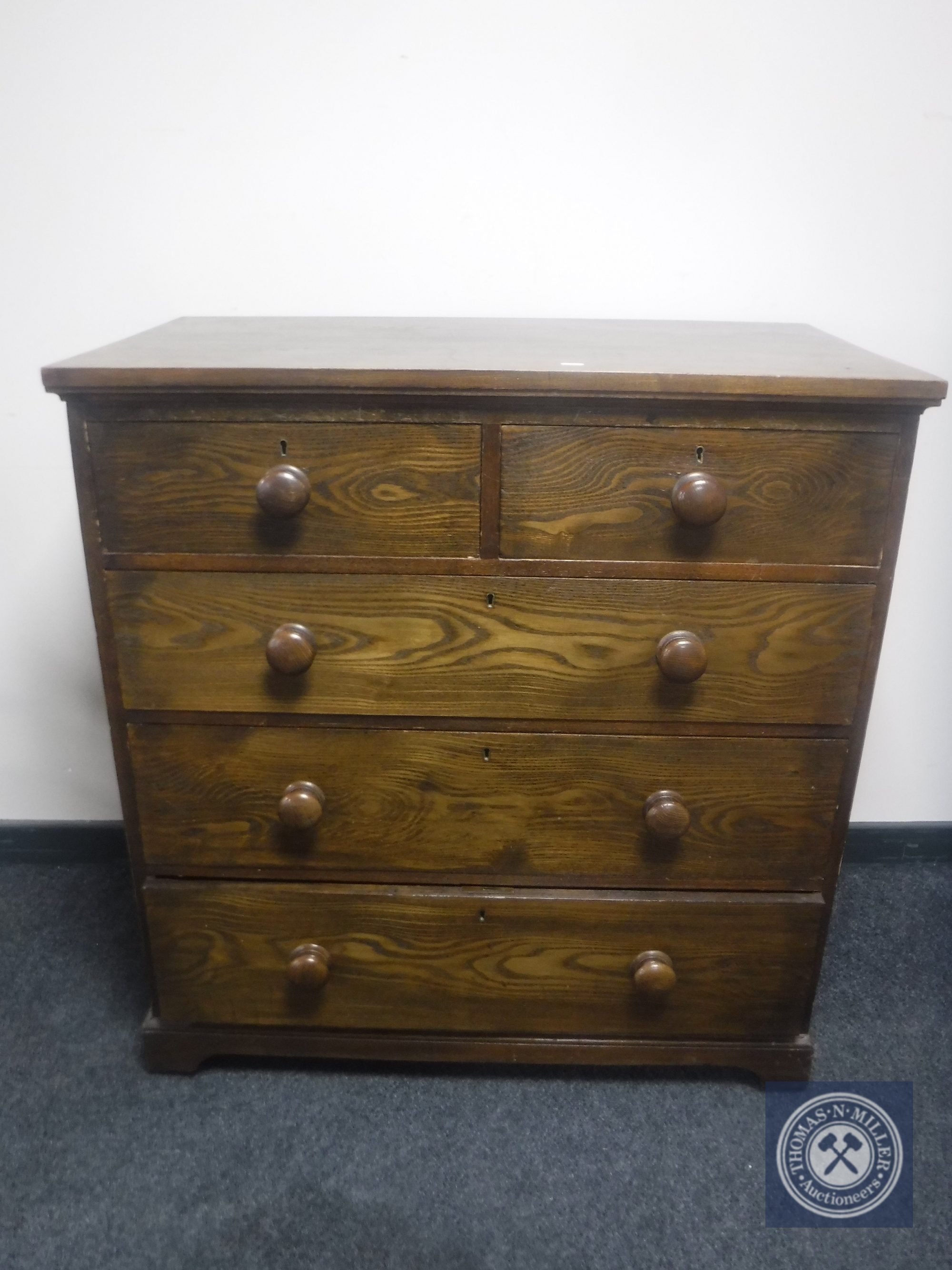 An Edwardian oak five drawer chest with knob handles