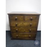 An Edwardian oak five drawer chest with knob handles