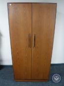 A mid 20th century G Plan teak bedroom suite comprising two double door wardrobes and an eight