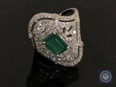 An 18ct white gold emerald and diamond ring featuring an emerald cut emerald 1.