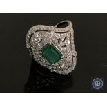 An 18ct white gold emerald and diamond ring featuring an emerald cut emerald 1.