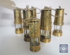A collection of seven miniature brass miner's lamps