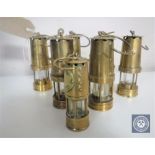 A collection of seven miniature brass miner's lamps