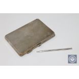 An antique silver card case containing a silver pencil