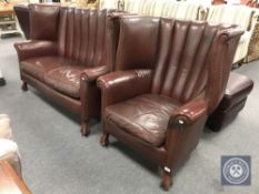 A brown leather wingback armchair with matching two seater settee