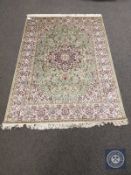A Keshan rug on green ground 200 cm x 140 cm