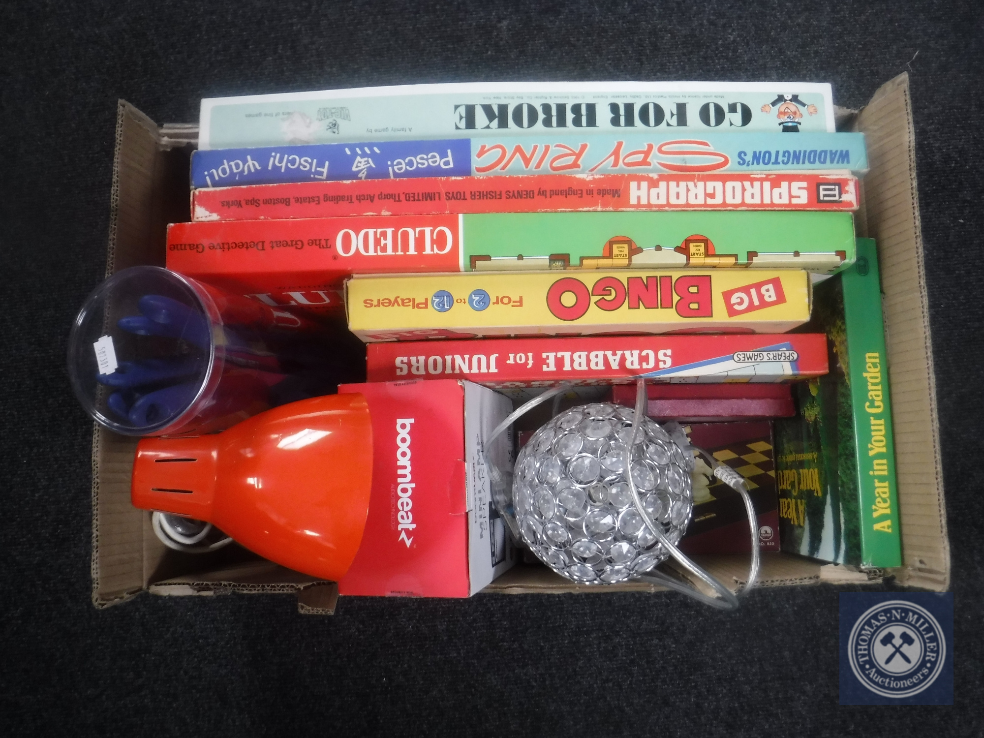 A box of board games, kitchen utensils,