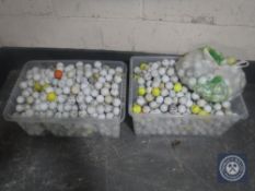 Two plastic tubs of golf balls