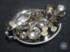 A plated twin handled gallery tray containing plated items, basket, napkin rings,