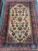 An Afghan Balouch rug, with central stylised geometric Tree of Life motif on coffee ground,