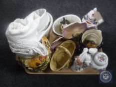 A tray of antique pottery jelly moulds, table linen,