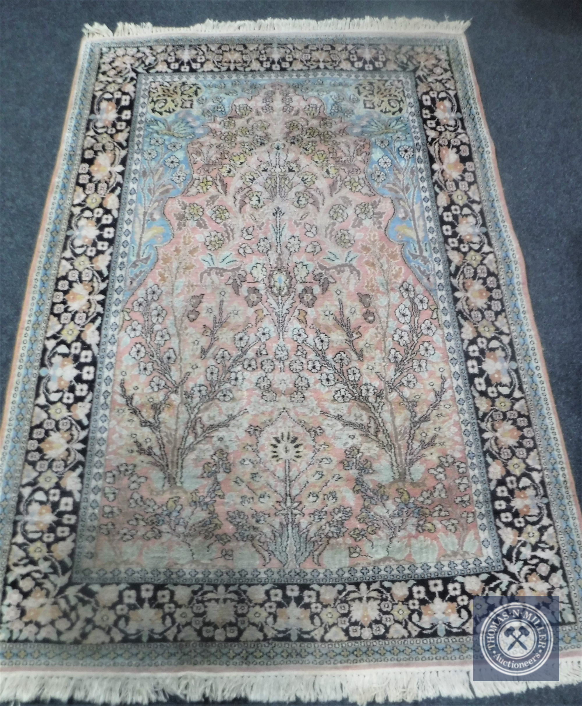 An Indian rug of Tree of Life design, on peach ground,