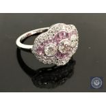 An 18ct white gold sapphire and diamond ring featuring 3 centre round brilliant cut diamonds,