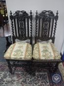 A pair of Victorian heavily carved oak hall chairs