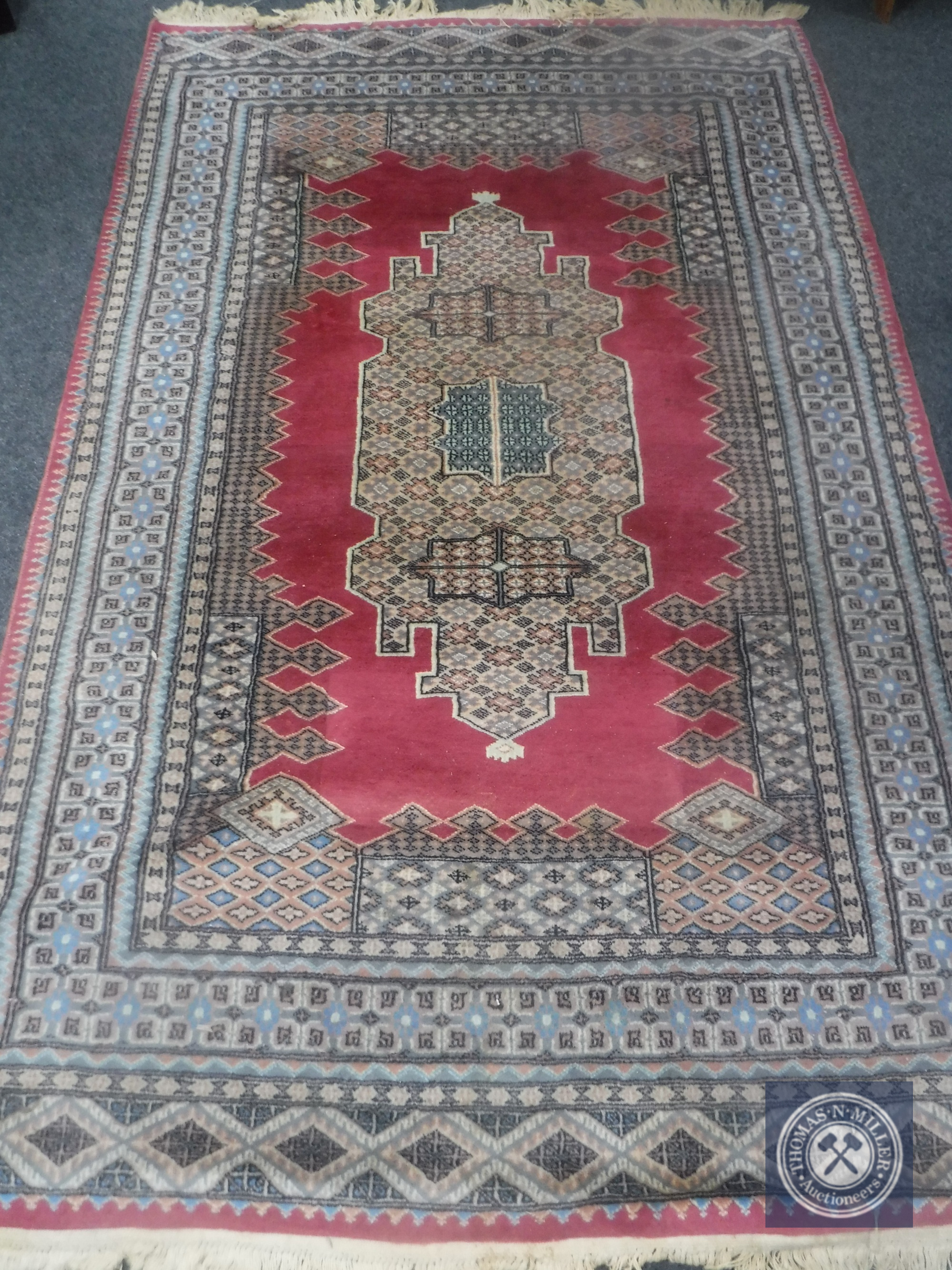 A Caucasian design rug on salmon ground,