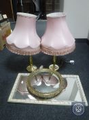 A pair of brass table lamps with pink tassel shades together with a gilt framed porthole mirror and