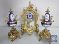 A three piece continental gilt and ceramic clock garniture with enamelled dial and pendulum