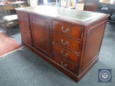 A mahogany office sideboard fitted three cupboards and inset green leather panel