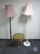 A circular leather topped drum table together with two standard lamps with shades