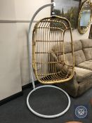 A 20th century hanging wicker chair on metal stand