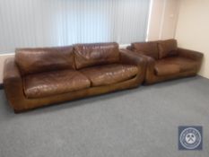 A contemporary leather three seater settee with matching two seater settee