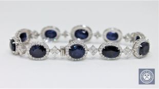An 18ct white gold sapphire and diamond tennis bracelet featuring 10 oval cut Kashmiri sapphires 24.
