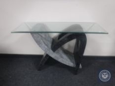 A contemporary glass topped side table on stone effect base