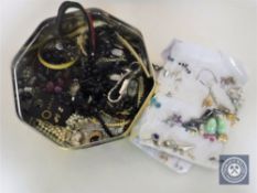 A tin of assorted costume jewellery, watches, folding knife,