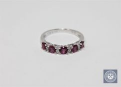 A 14ct white gold ruby and diamond ring featuring five round cut natural rubies 0.