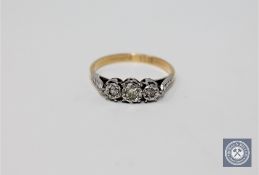 An 18ct gold and platinum set three stone diamond ring, approximately 0.25ct, size K 1/2.