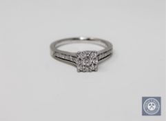 A platinum and diamond cluster ring set with diamond shoulders, size K 1/2.